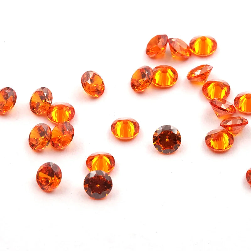 A collection of loose, round-cut orange-colored cubic zirconia stones for jewelry making.