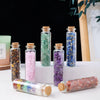 A collection of natural crystal healing drifting bottles in various colors and sizes displayed on a white surface.