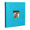 A teal linen front scrapbook memory book with a photo of a family.