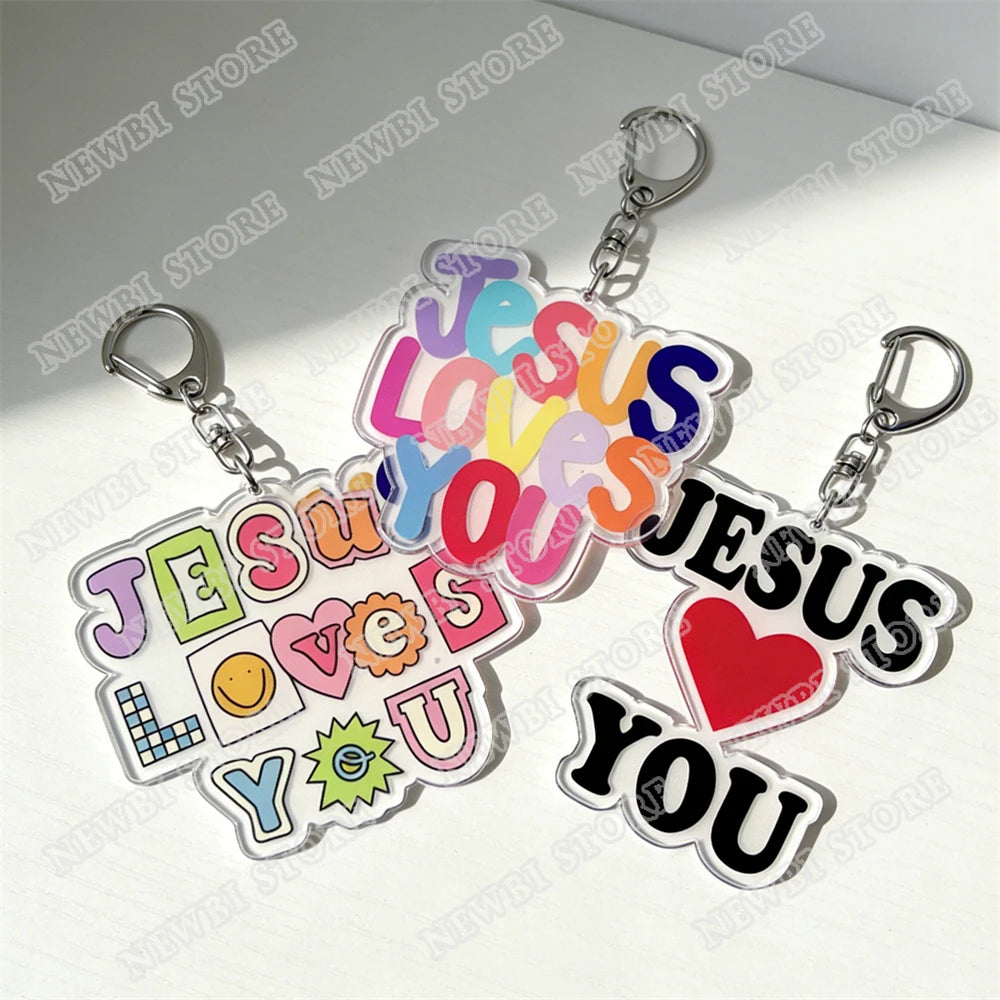 Klares Acryl-Anhänger mit der Aufschrift „Jesus liebt dich“ in bunten Buchstaben und einem roten Herzen.