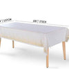 A white rectangular table draped with a sheer white cloth and gold polka dots, shown in a studio setting.