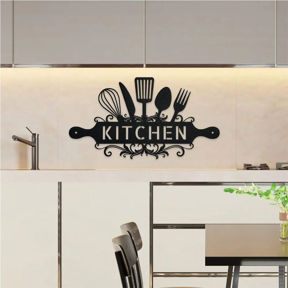 A black metal wall sign featuring kitchen utensils like whisks, spatulas, and forks, mounted on a light wood background.