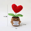 Handmade crochet plant decoration featuring a red heart flower growing from a brown potato with an inspirational card.
