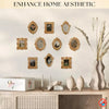 A gallery wall display featuring ten vintage resin picture frames in various sizes and gold tones on a light wall.