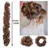 Cheveux d'une femme coiffés en chignon élégant avec des boucles lâches et un élastique synthétique en tissu.
