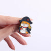 A hand holds a set of enamel pins featuring cartoon cats with rude middle finger and daisy flower designs.