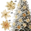 Set of eight glittered artificial gold flowers with clips displayed next to a decorated Christmas tree.