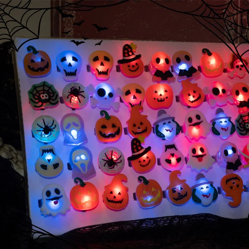 A display of Halloween glow rings featuring pumpkins and spooky faces, used as light-up party favors.