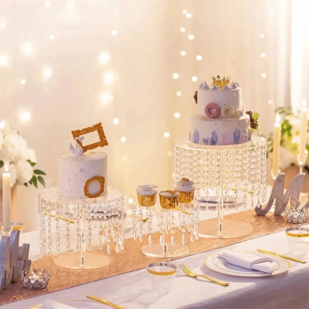 Elegant transparent acrylic cake display rack with a tiered white cake decorated for a celebration.
