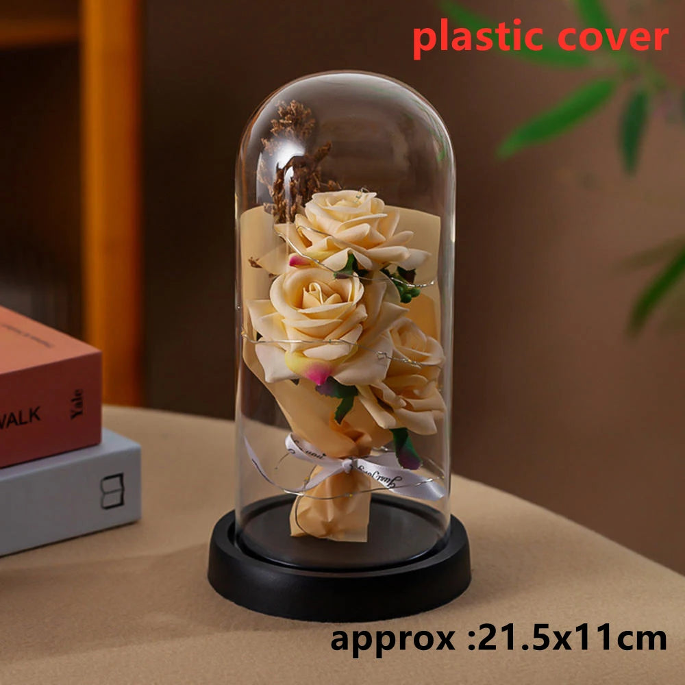 A glass dome display featuring an artificial yellow rose flower.