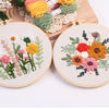 Punch needle embroidery kit featuring floral designs on stamped cloth with tools and yarn