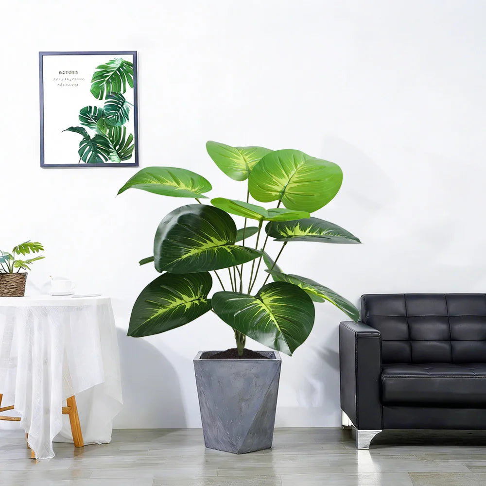A large artificial palm tree with vibrant green leaves in a gray planter on a modern living room shelf.