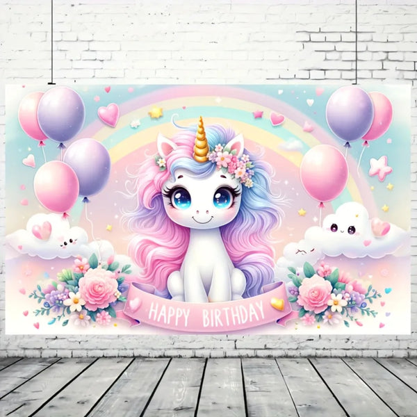 A pastel pink unicorn with a golden horn sits amidst balloons, rainbows, and flowers against a light blue background.