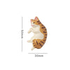 A cute, cream-colored cat figurine with orange stripes, shown in profile against a white background.