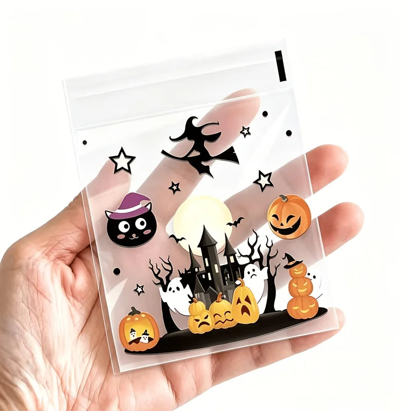 A hand holds a clear self-adhesive treat bag filled with Halloween-themed pumpkin and spooky icons.