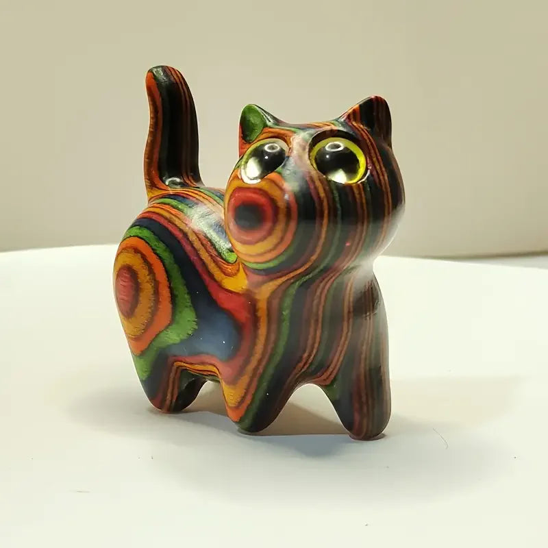 Hand-painted wooden sculpture of a kitten with swirling multicolored stripes.