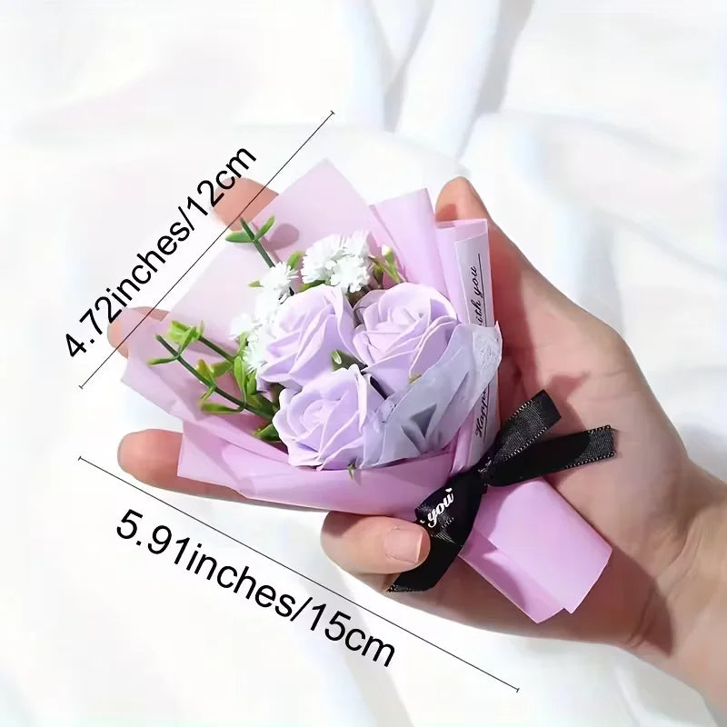 Une main tient une décoration en papier rose avec des roses violettes et un ruban noir.