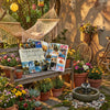 A vision board book with inspirational stickers and quotes displayed on a wooden shelf surrounded by potted plants.