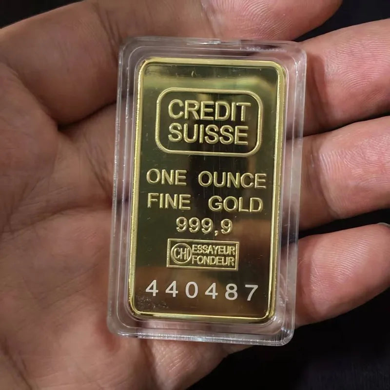 A clear plastic holder containing a gold coin labeled Credit Suisse One Ounce Fine Gold 999.9