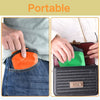 A hand places an orange cooling fan into the pocket of blue jeans, demonstrating its portable design.