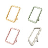 A set of three wavy frame makeup mirrors in beige, light green, and pink with stands.