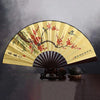 A retro folding silk and bamboo decorative fan with a light yellow background featuring red blossoms and birds.