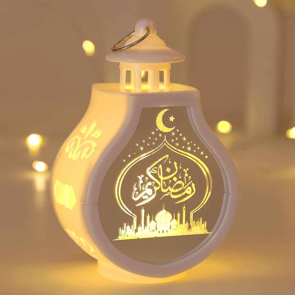 A white LED lantern shaped like a dome with an etched crescent moon and Arabic calligraphy for Ramadan and Eid