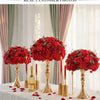 A centerpiece featuring a red silk champagne rose and hydrangea flower ball surrounded by rose petals.