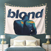 A tapestry featuring a silhouette of a person with blonde hair against a light background, illuminated by string lights.