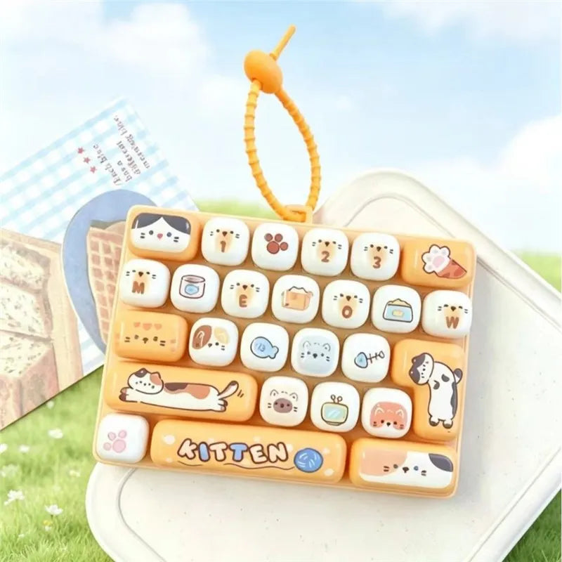 A yellow silicone keyboard keycap set featuring various cartoon animal designs and a dangling orange loop.