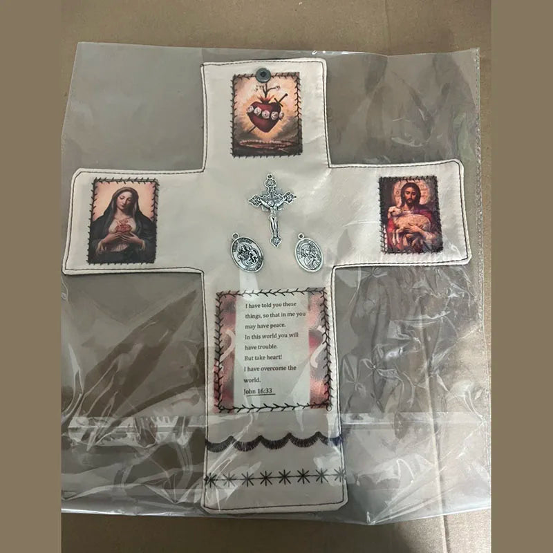 Handcrafted pocket shrine featuring a cross and religious imagery on a white fabric background.