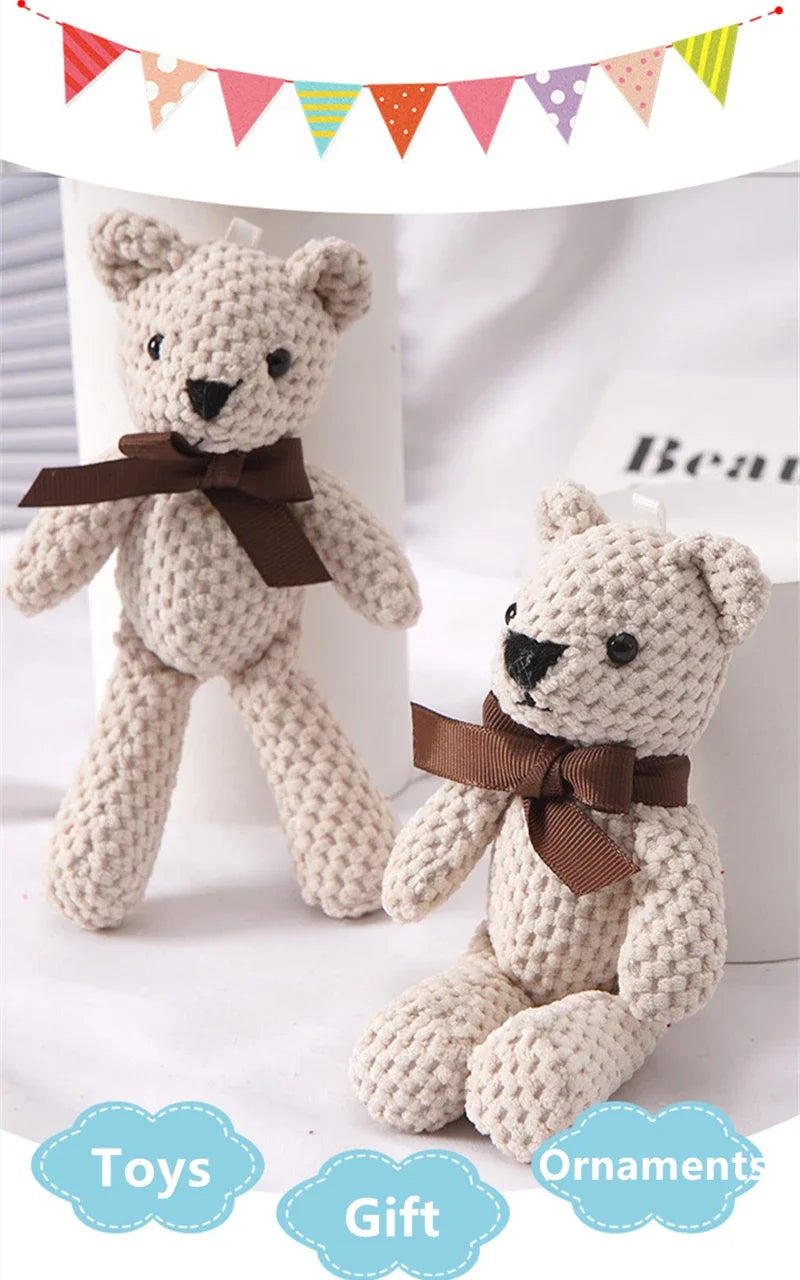A light beige crocheted stuffed bear toy with a brown bow, displayed next to a gift ornament.