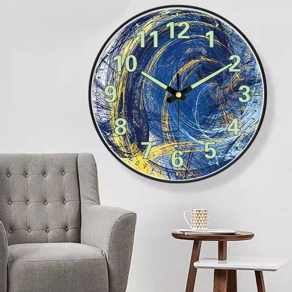 A minimalist round wall clock with a blue and yellow abstract design on a white background.