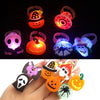 A hand holds several glow rings featuring Halloween-themed designs like pumpkins, skulls, and spiders.