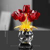 A bouquet of red crystal roses displayed in a clear glass vase on a dark surface.
