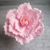 A large, pink silk foam rose flower with layered petals and a yellow center.