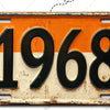 Señal de pared de aluminio vintage con el año 1968 grabado en negro sobre fondo naranja y blanco.