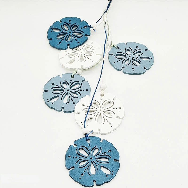 A set of twelve wooden ocean ornaments in shades of blue and white, shaped like shells, scallops, and starfish.