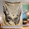 A fabric wall tapestry featuring text We're a Team and an image of two hands clasped together.