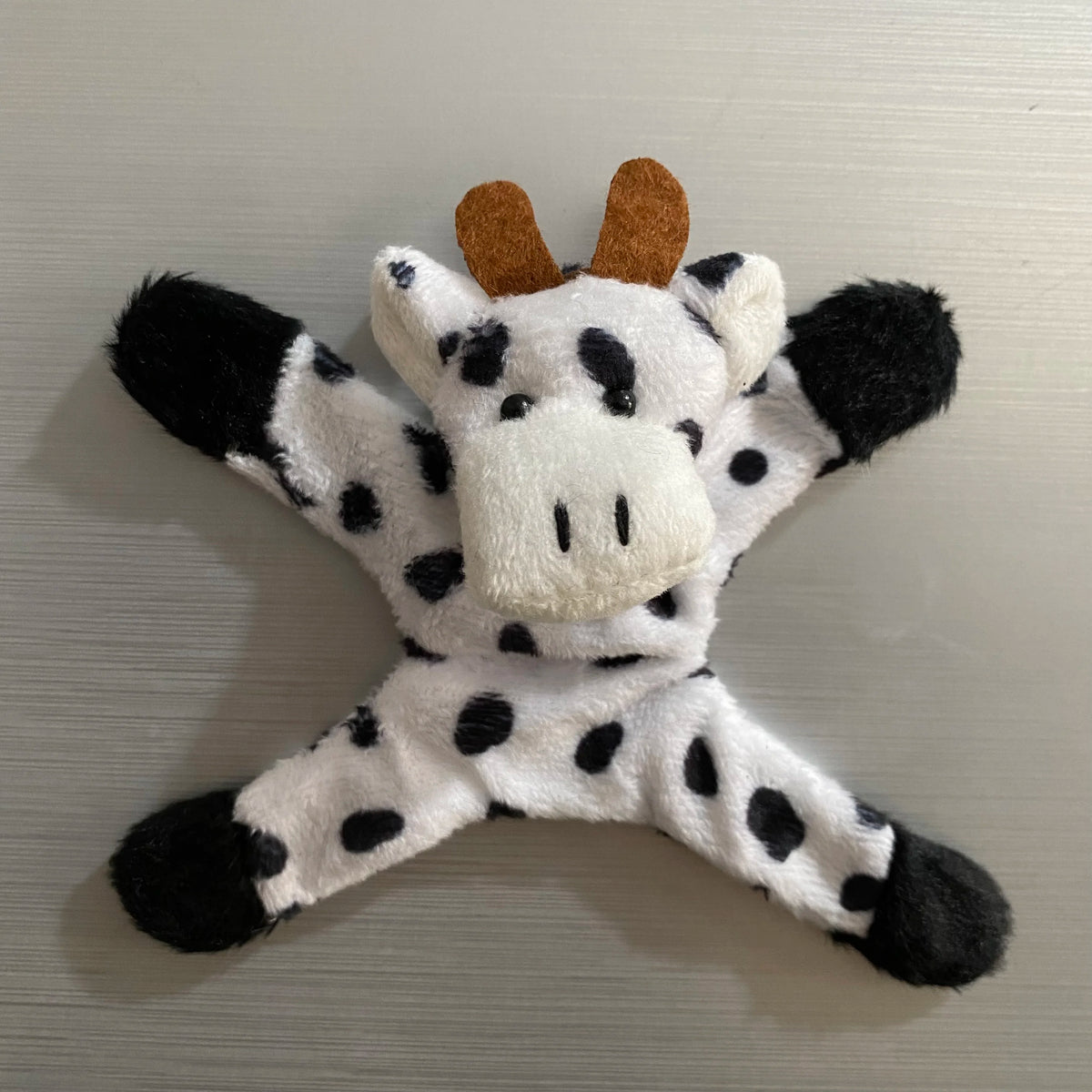 A plush elephant toy with black and white spots and brown ears.