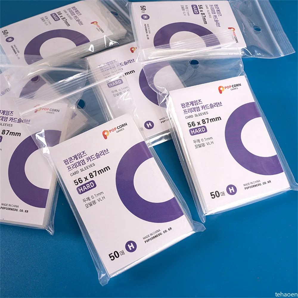 A collection of clear protective card sleeves in purple and white packaging, showing various sizes like 56 x 87mm and 50 mm.
