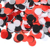A pile of round tissue paper confetti dots in red, black, and white.