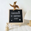 A wooden letter message board with a fan cutout displaying the text Tomorrow is another day.