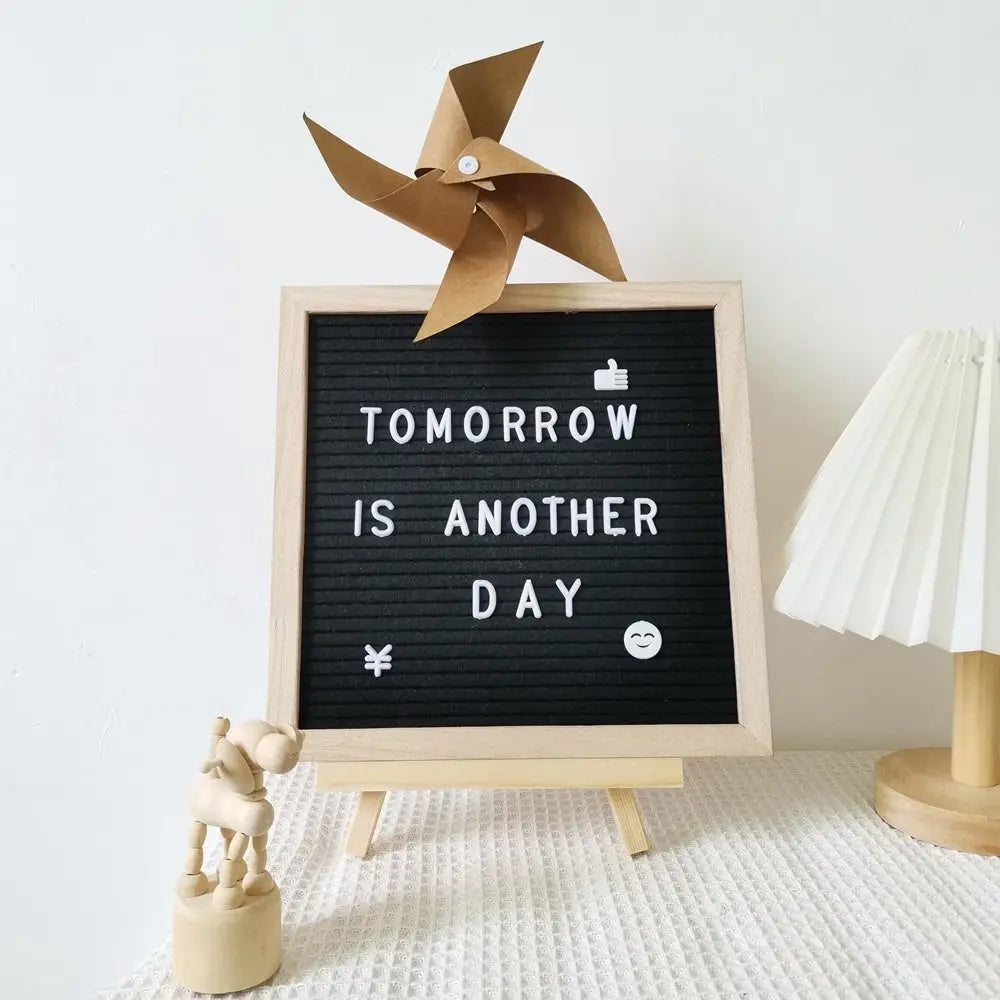 A wooden letter message board with a fan cutout displaying the text Tomorrow is another day.