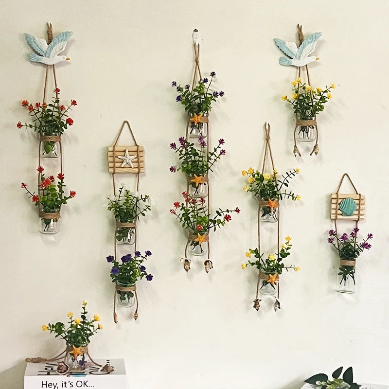 A collection of decorative glass terrariums filled with various indoor plants hanging on a white wall.