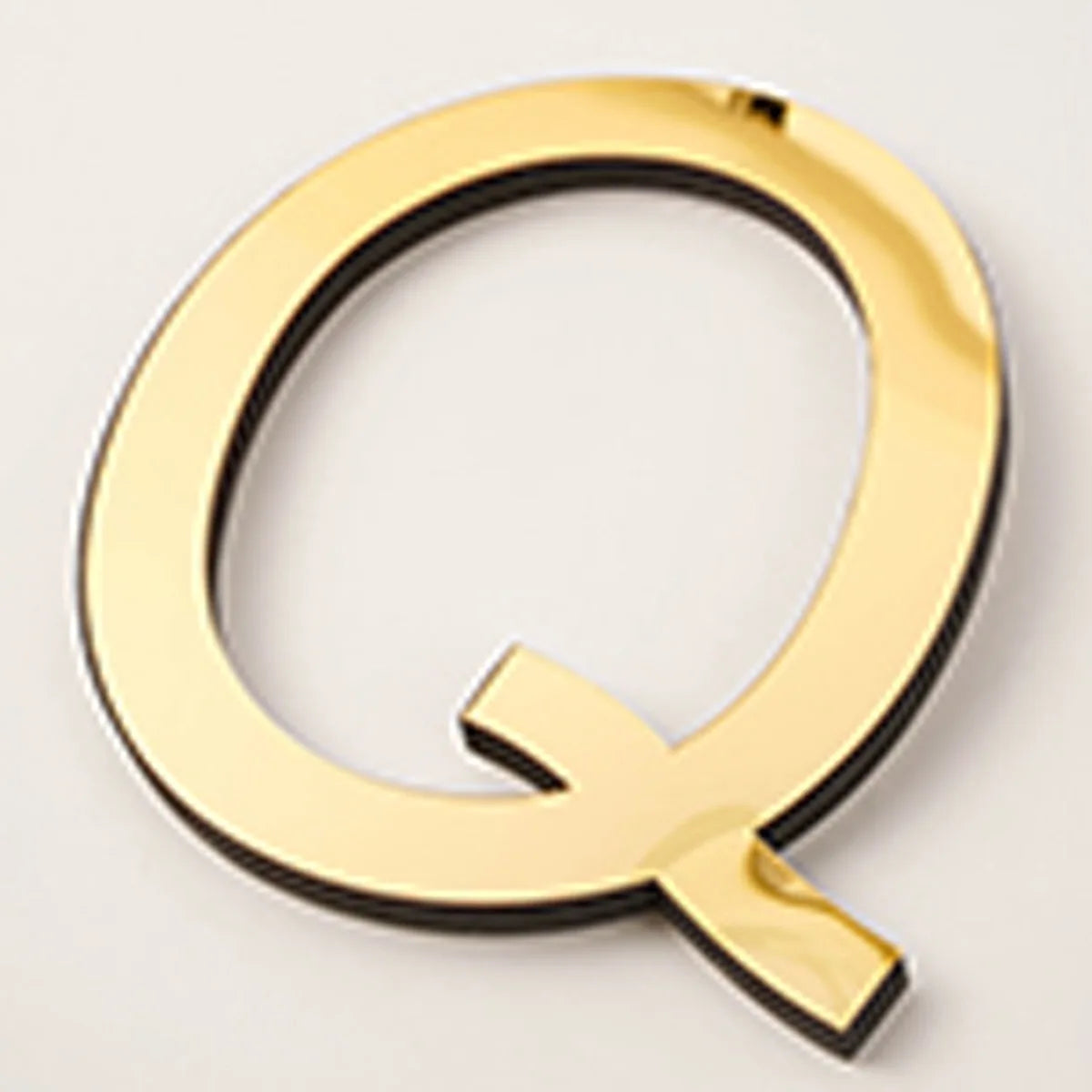 A gold acrylic mirror letter Q wall sticker with a pointed bottom, used for self-adhesive decor.
