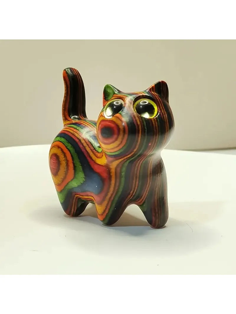 Hand-painted wooden kitten sculpture with vibrant, swirling colors and large eyes.
