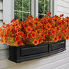 Arrangement de fleurs artificielles d'automne et d'Halloween en pot, sur un mur de revêtement blanc extérieur.