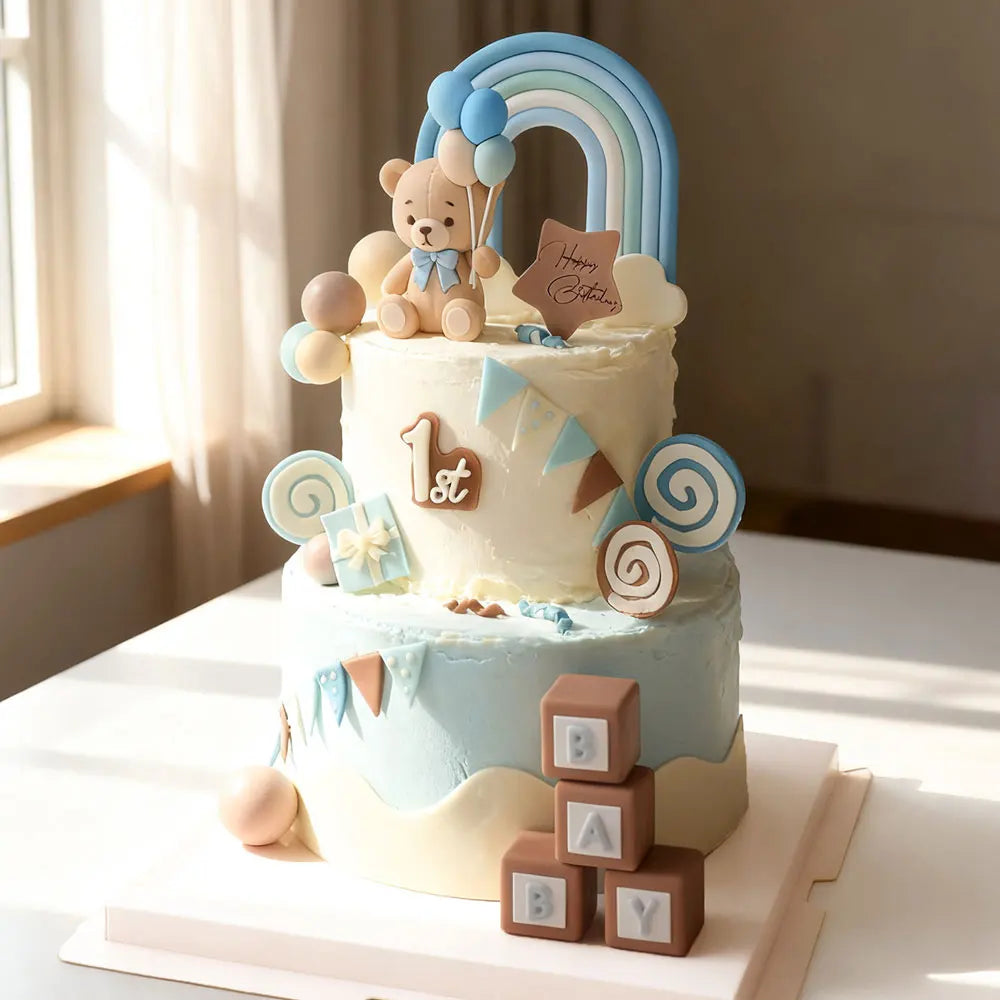 A tiered cake decorated with blue and white frosting, featuring bear toppers and a rainbow arch.