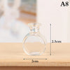 Clear glass miniature dollhouse vase and wine bottle set on a wooden surface